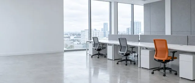 A bright open office with desks and one orange chair